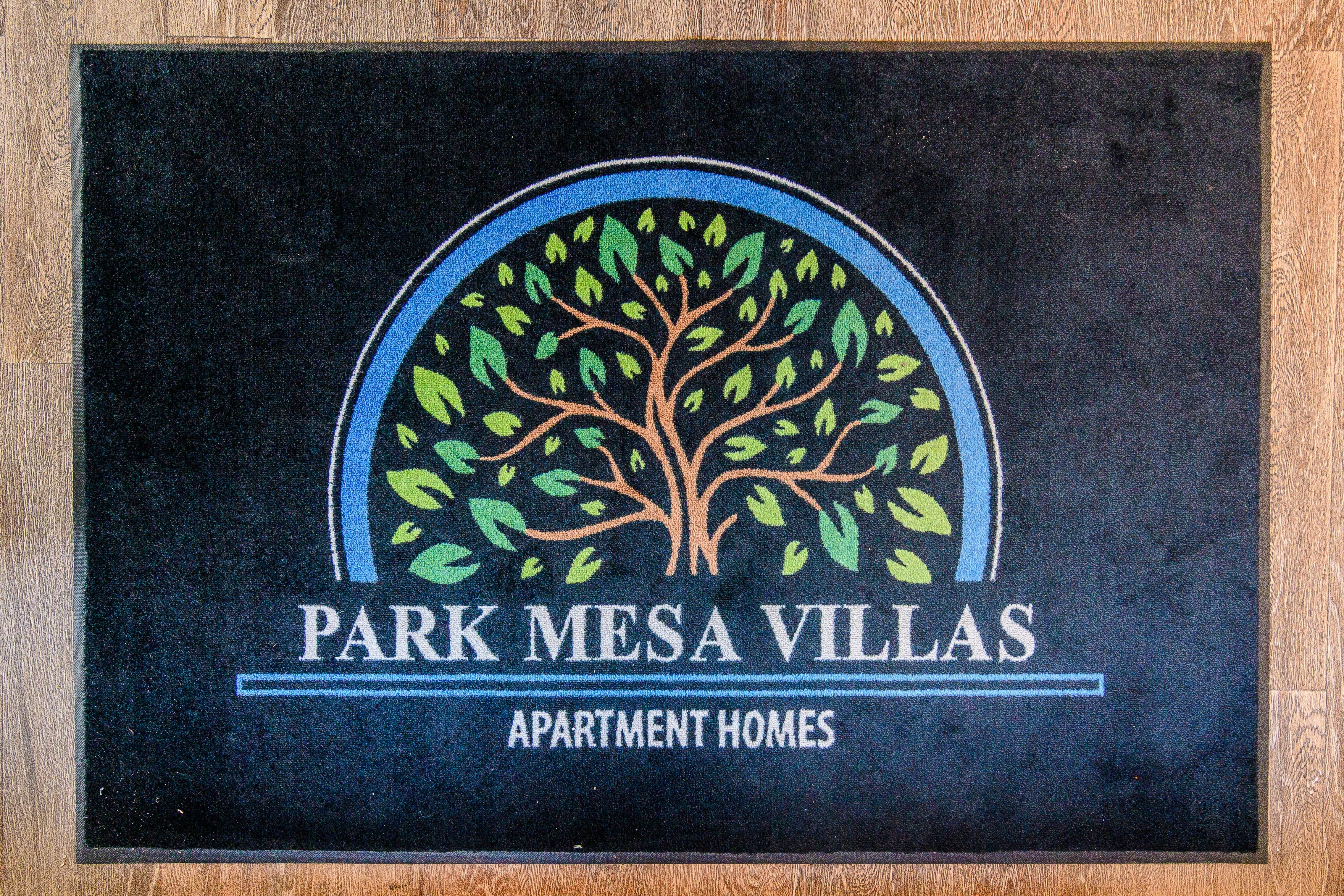 A sign for Park Mesa Villas Apartment Homes with a tree design.